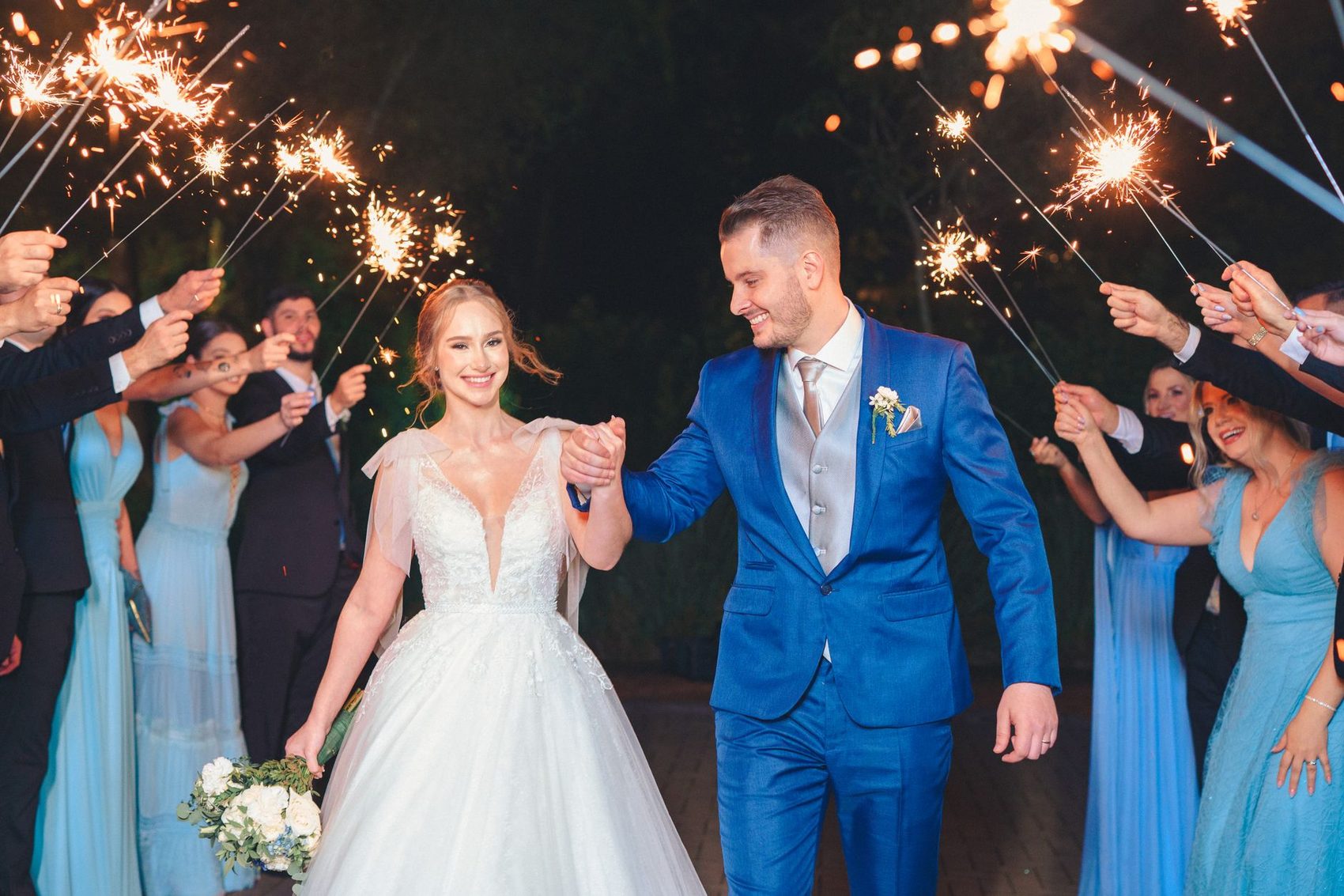 Couple leaving through a line of sparklers